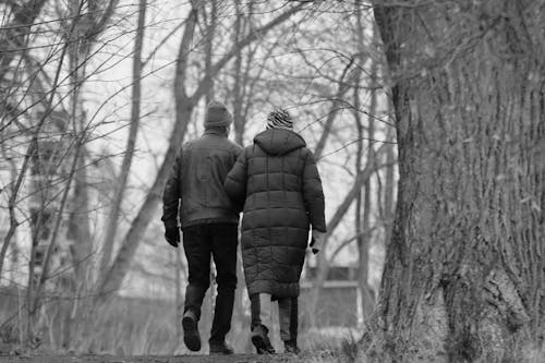 Man and Woman Walking Together among Trees