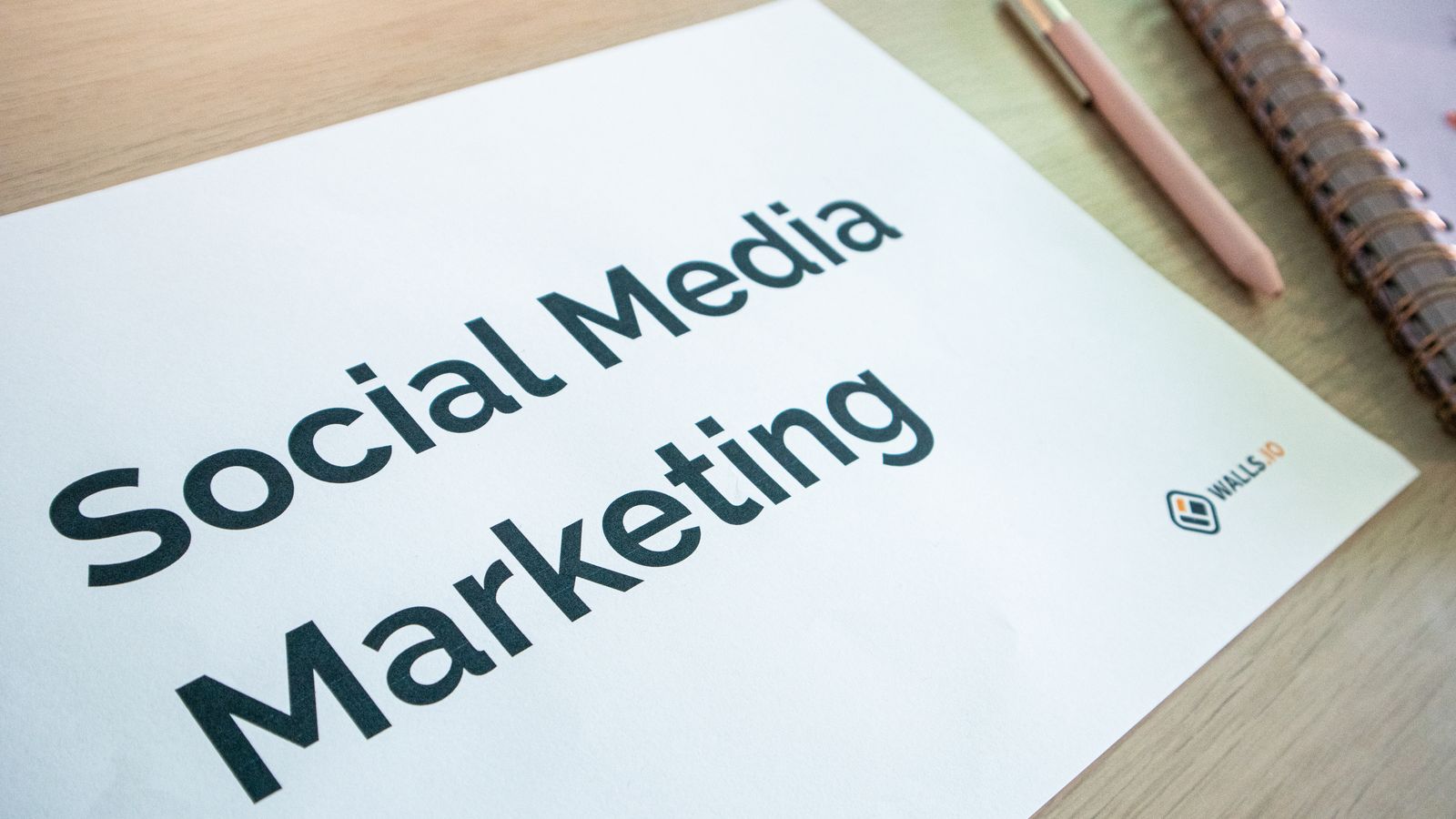 Plan marketingu i social media na biurku z notatnikiem i długopisem