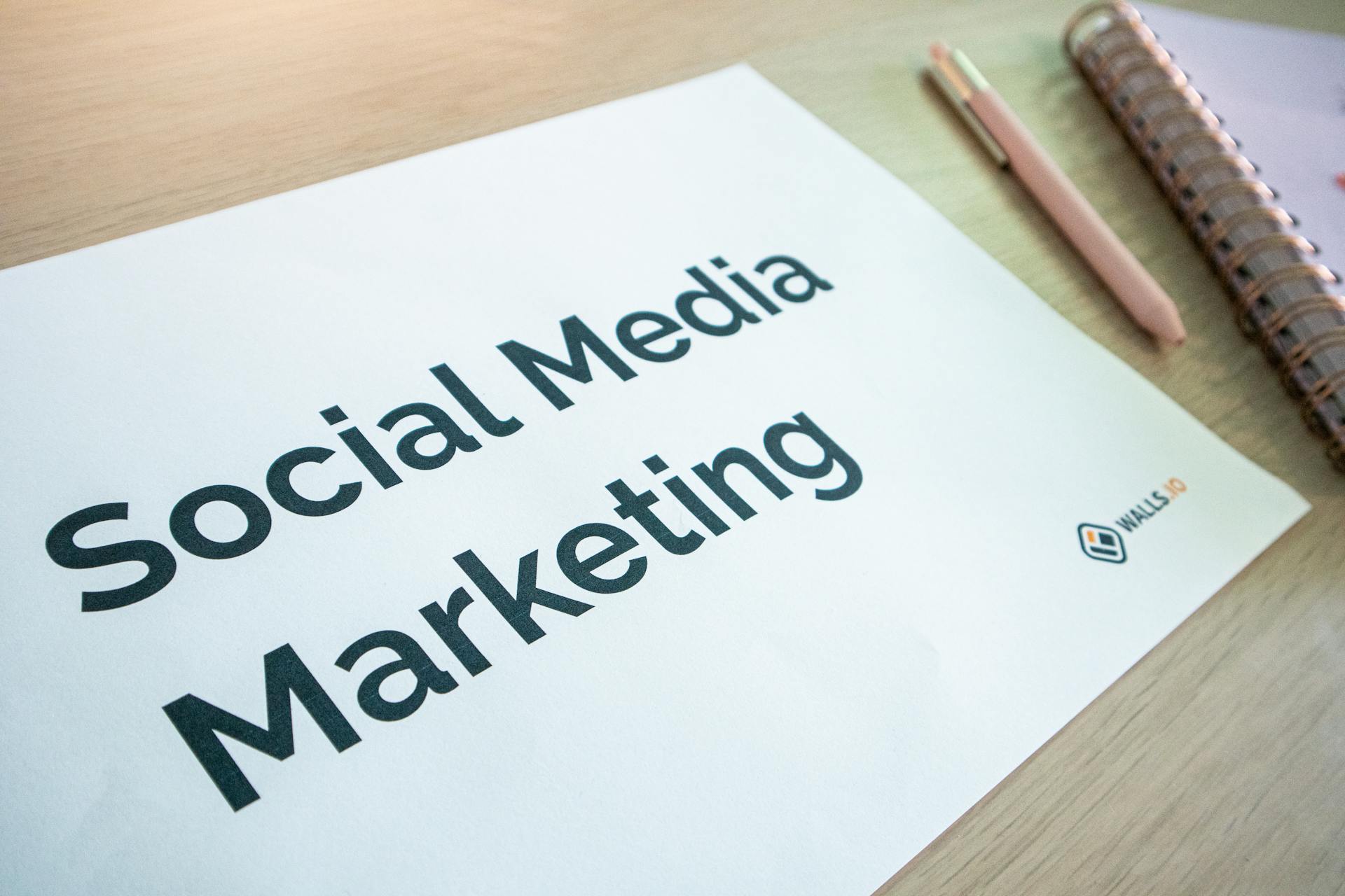 Close-up of a social media marketing document on a desk with a pen and notebook.