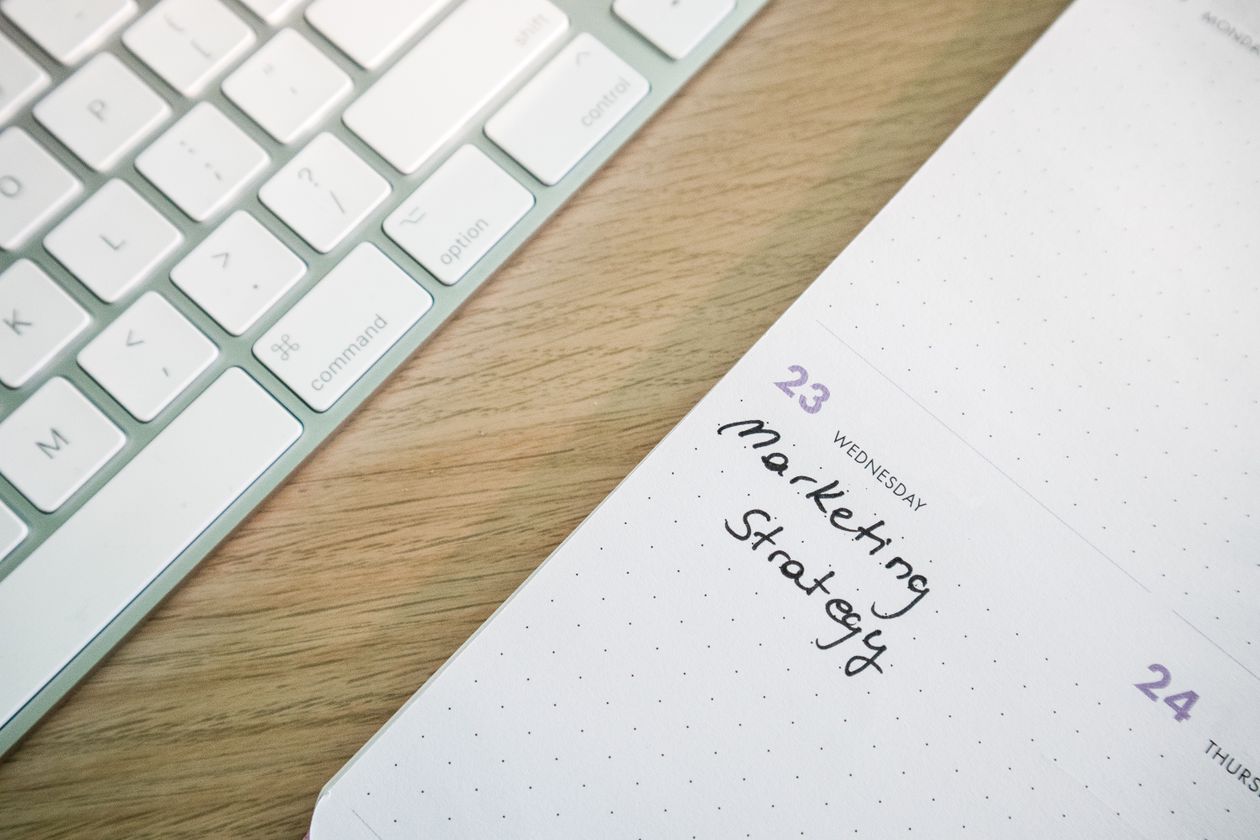 A close-up of a desk with a planner and notes during a marketing strategy session