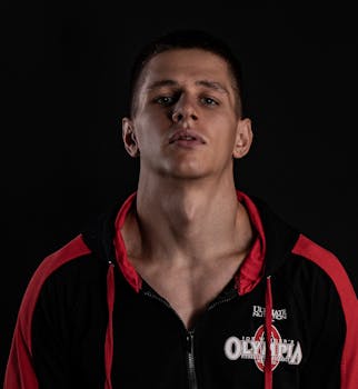 Studio portrait of a determined young man in sportswear on a black background.