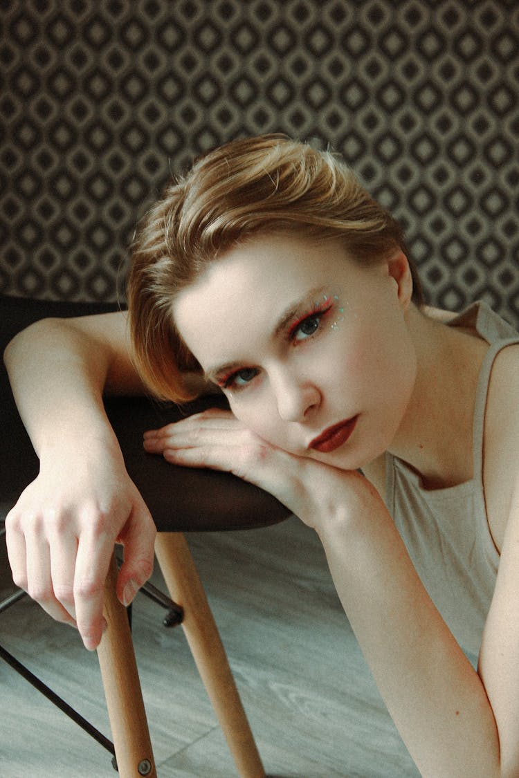 Woman With Makeup Posing Near Chair