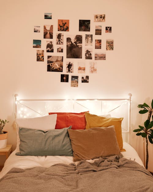 Photographs Arranged in Heart Shape on Wall above Bed