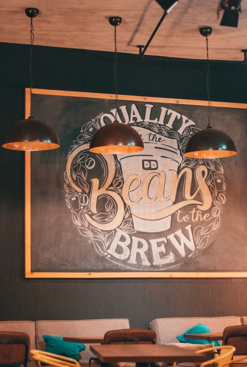 Free Warm cafe setting featuring chalkboard art with cozy seating. Stock Photo