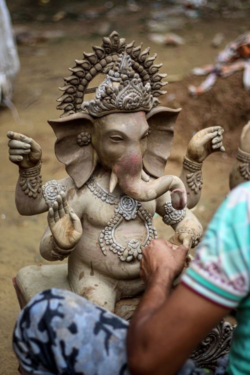 Free Artisan sculpting a detailed Ganesha statue, showcasing Indian cultural craftsmanship. Stock Photo