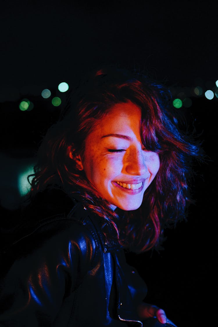 Illuminated Face Of A Smiling Woman At Night