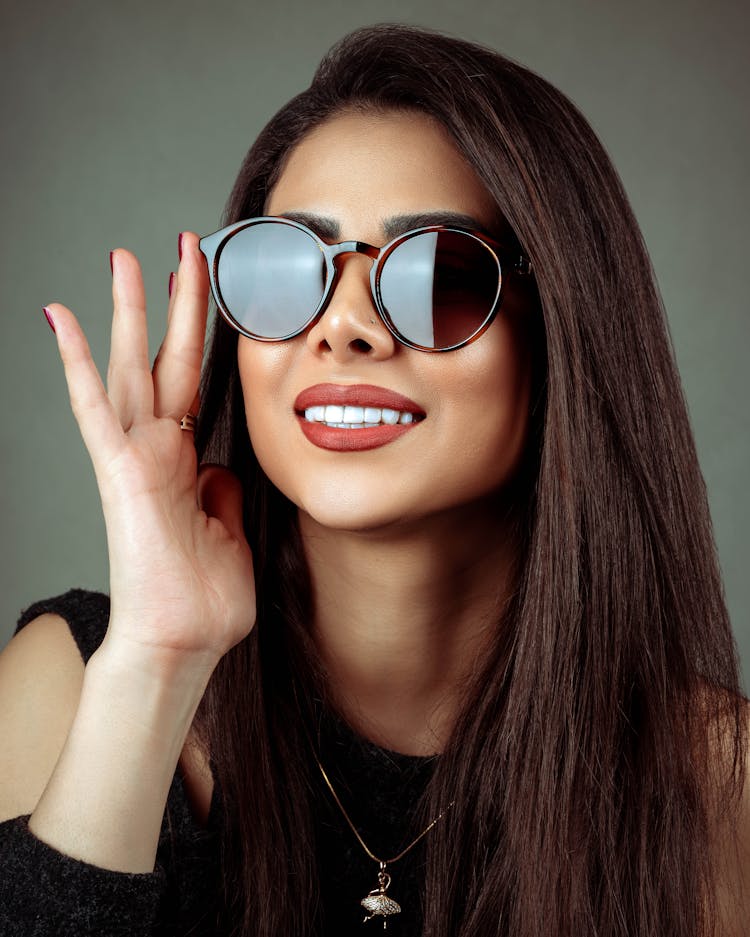 Smiling Woman In Sunglasses In Studio