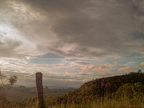 Immagine gratuita di cielo nuvoloso, collina, filo spinato