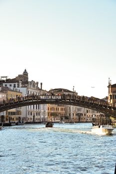 Scenic view of the historic bridge over Venice's Grand Canal with boats passing by.