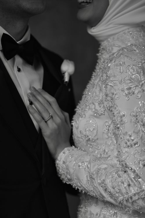 Free A classic black and white portrait of a bride and groom in formal attire, highlighting delicate details. Stock Photo