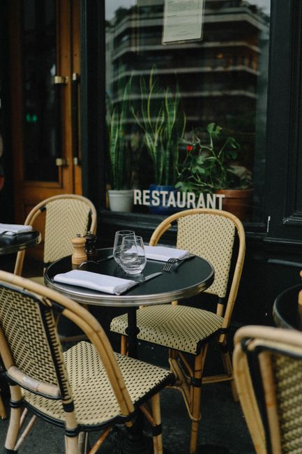 Charming outdoor restaurant setting with wicker chairs and tableware, ideal for al fresco dining.