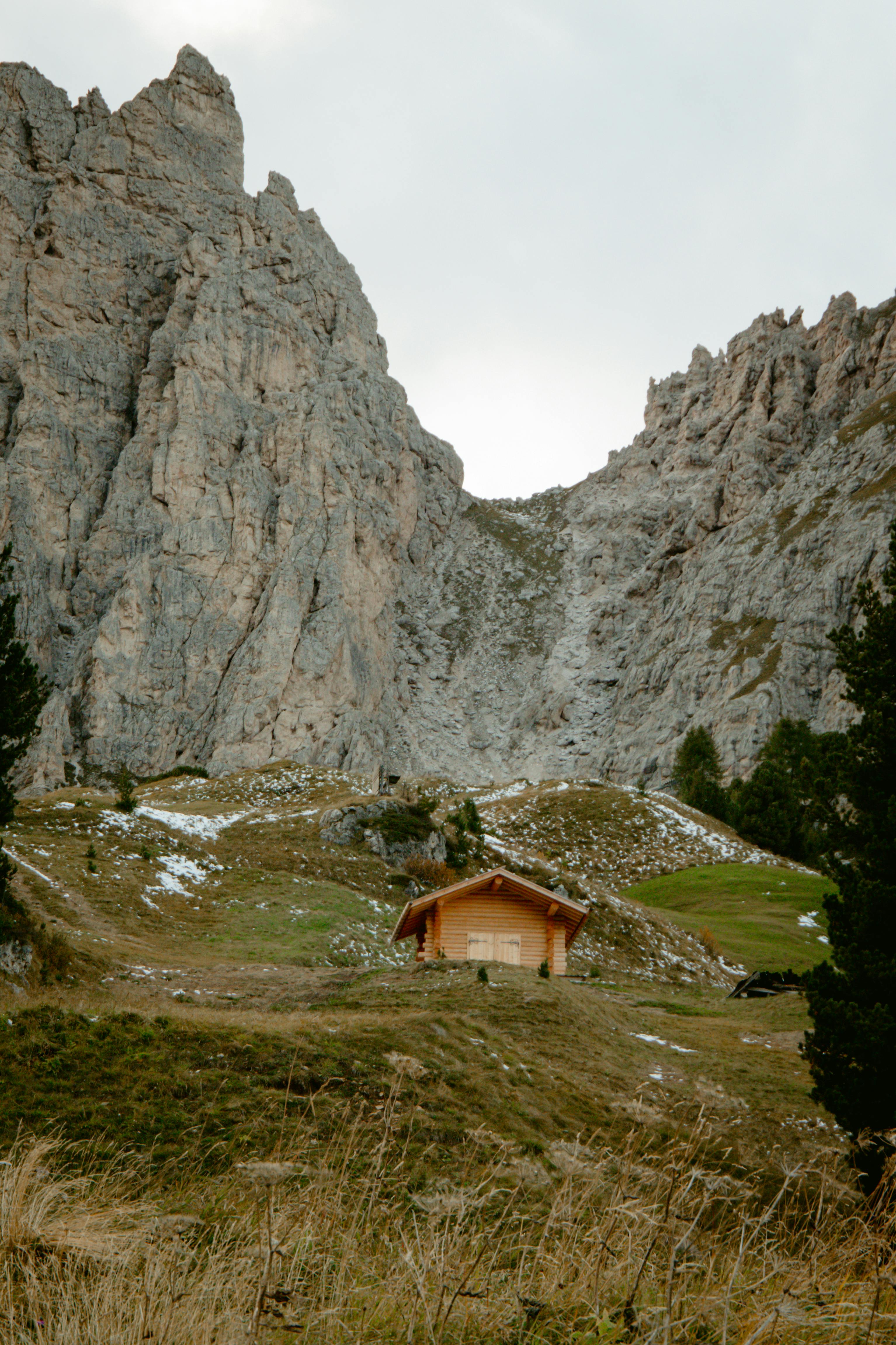 Rustic wooden hut nestled amidst the dramatic Dolomite mountains in Veneto, Italy.