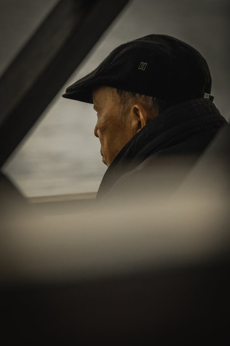 Candid Picture Of An Elderly Man Wearing A Cap And A Scarf 