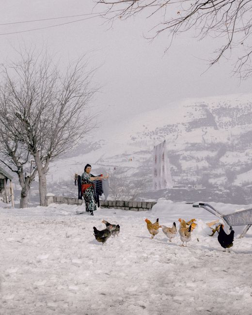 A woman hangs laundry outdoors in snowy Yardimli, Azerbaijan.