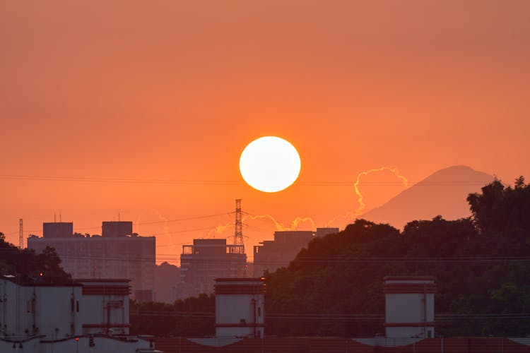 Silhouetted City Skyline And A Mountain At Sunset 