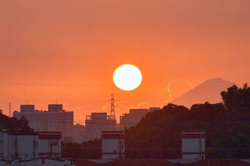 Free A vibrant urban skyline at sunset, featuring silhouetted buildings and Mount Fuji. Stock Photo
