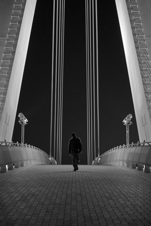 Lone Person on Bridge at Night