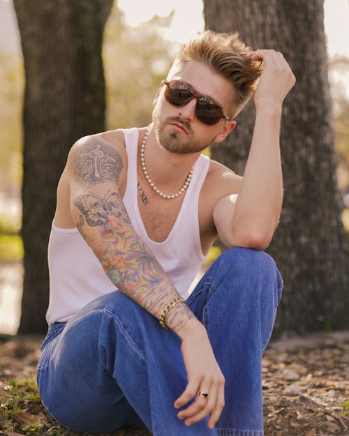 Man with Tattoos Sitting in Tank Top