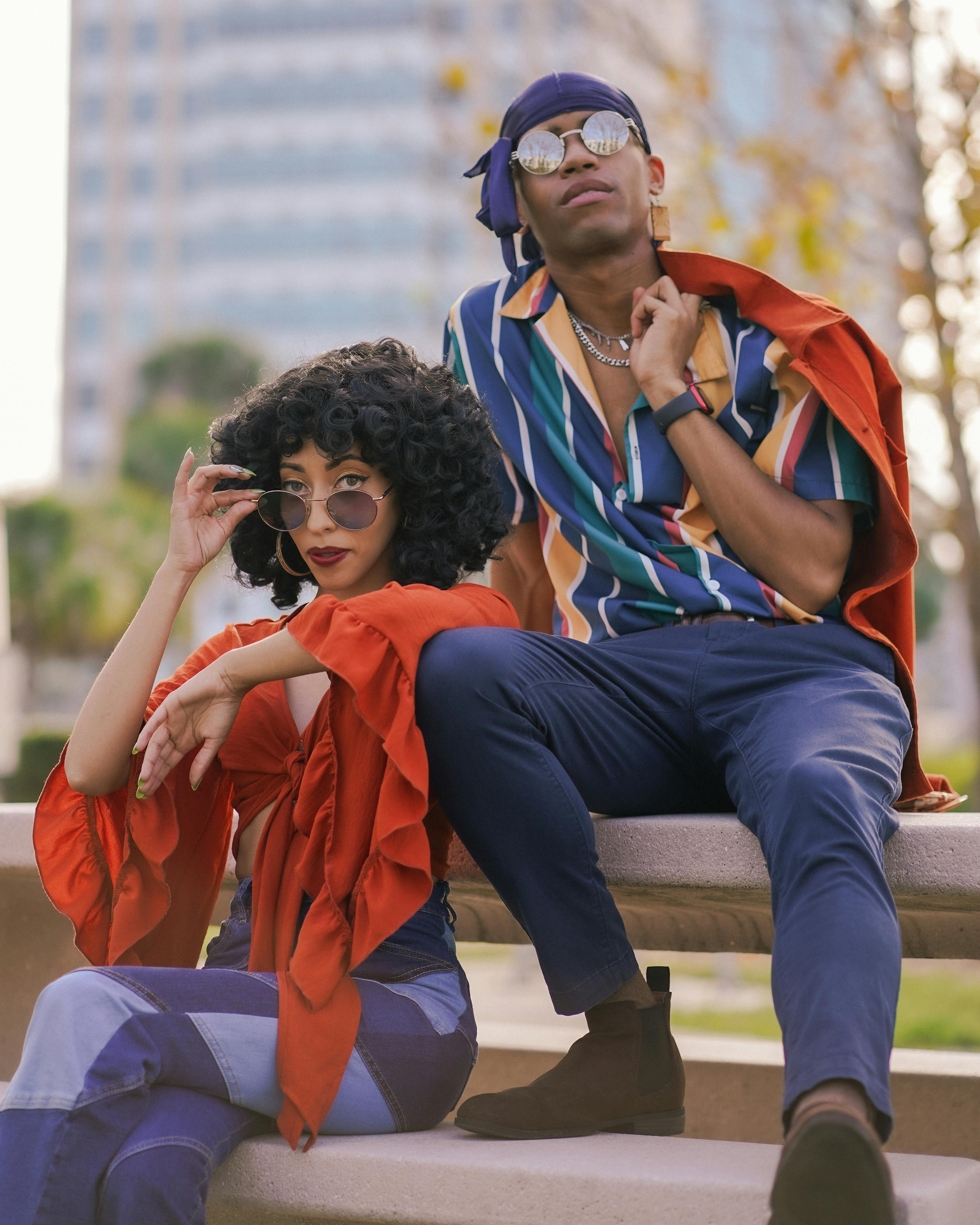 couple in sunglasses sitting on wall
