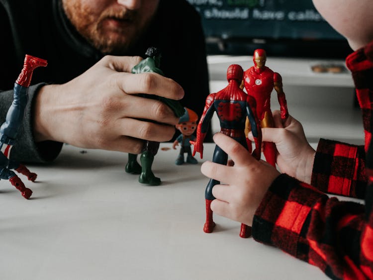 Father And Son Playing With Superheroes Toys