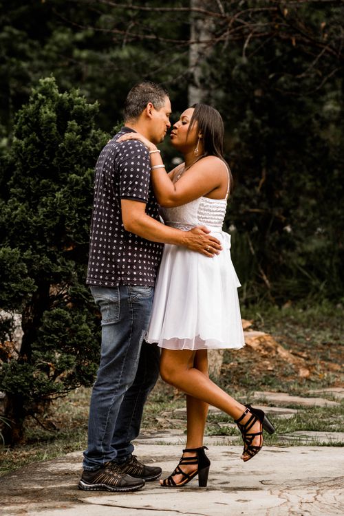 Free A loving couple shares a tender moment outdoors, surrounded by lush greenery in a natural setting. Stock Photo