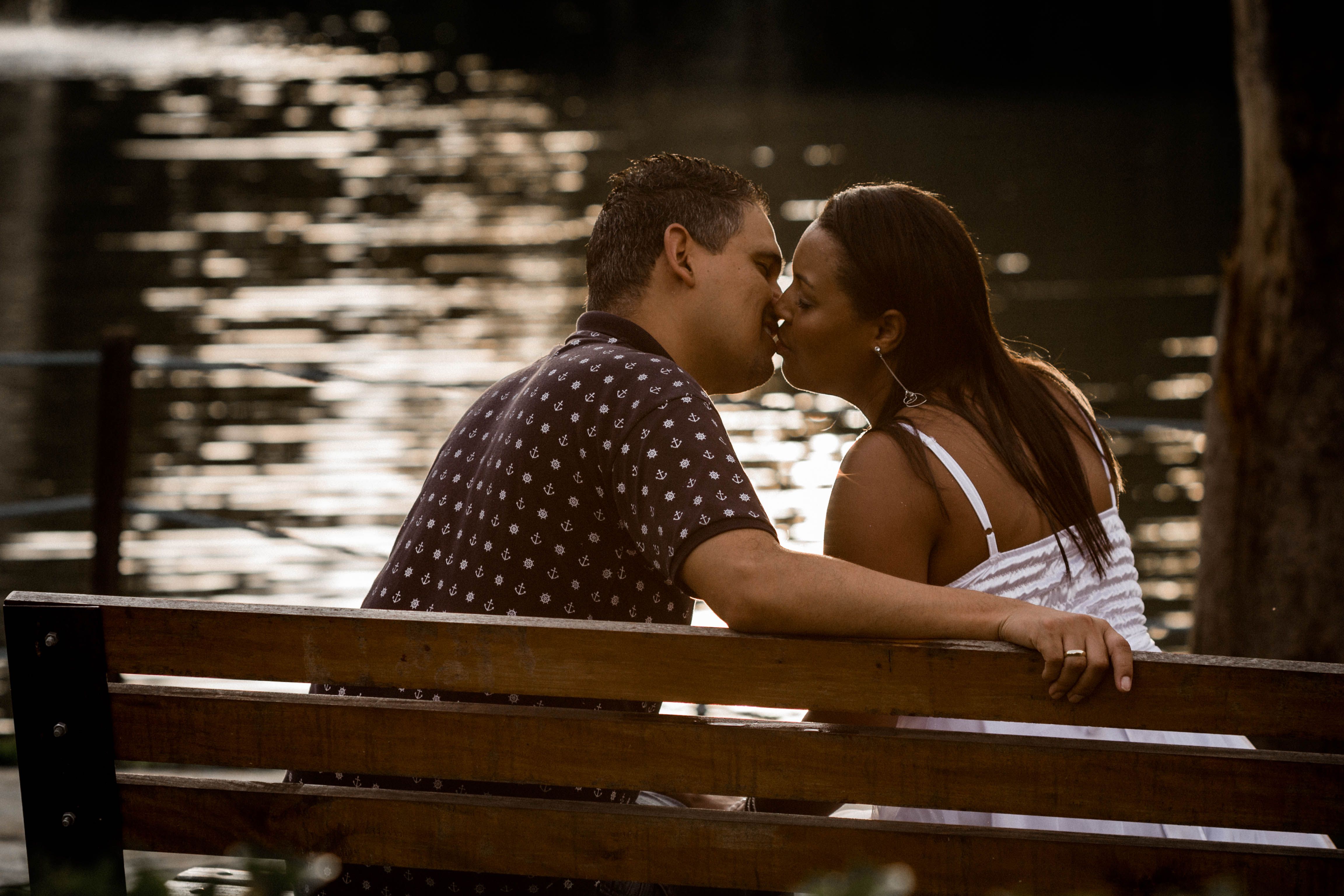 A Couple Sitting on a Bench and Kissing · Free Stock Photo