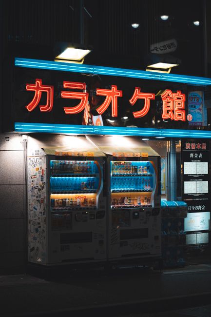 Night view of neon-illuminated vending machines on a street in Shibuya, Tokyo, Japan.
