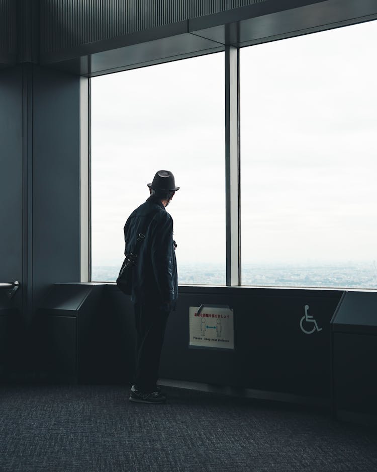 Man In Hat Looking In Building Big Window