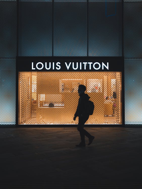 The person's black silhouette with the Louis Vuitton light sign