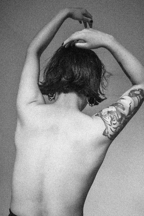 Back of a Half-naked Woman with a Tattoo on Her Arm