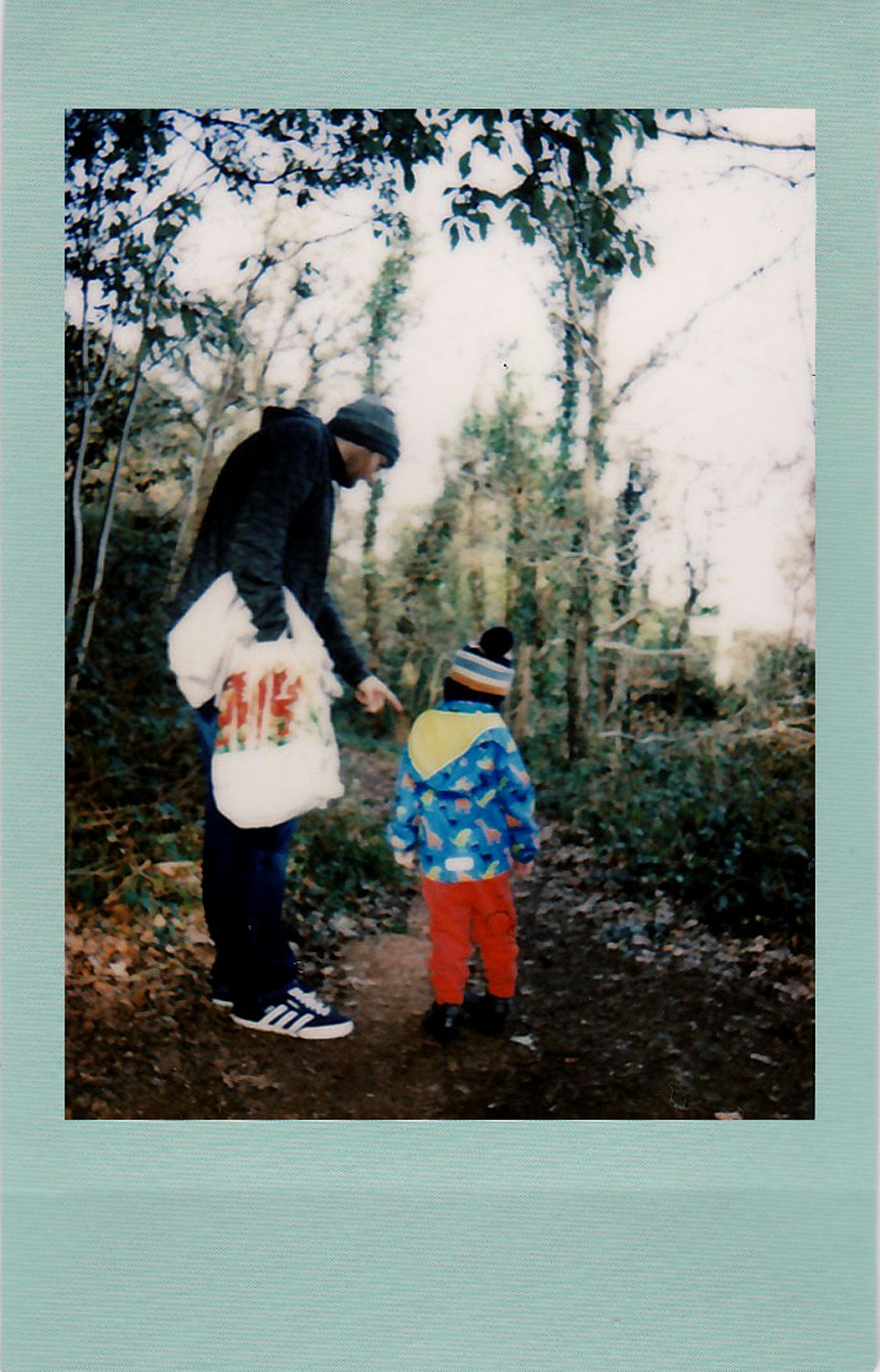 A father and son explore a scenic wooded path, capturing a bonding moment amidst nature.