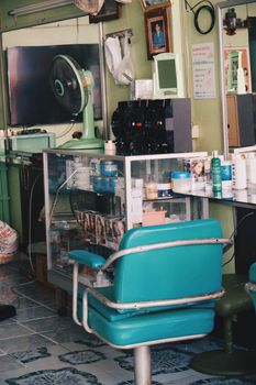 A cozy vintage barber shop interior featuring a teal chair and classic decor. Perfect for retro styling themes.