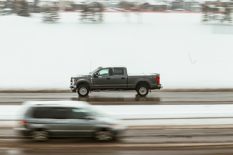 Grey crew-cab pickup panning past a snowfield, photo by Sukhan Sivia on Pexels