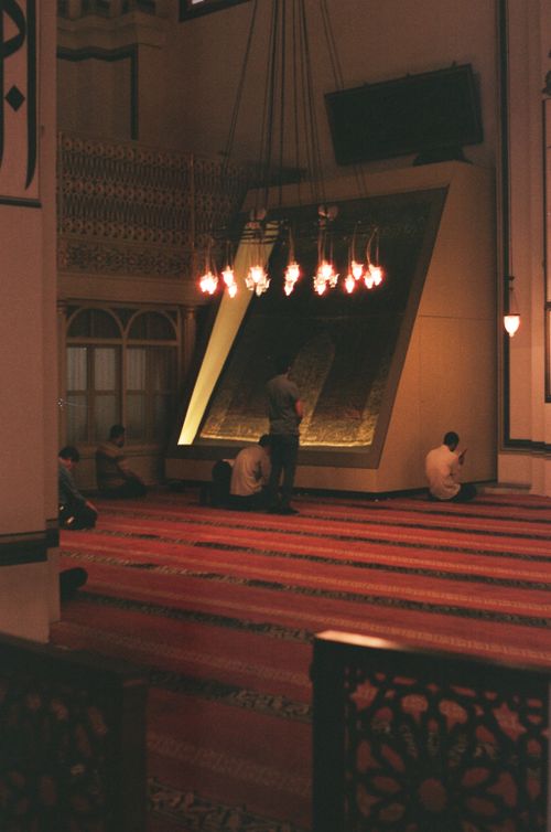 Free A serene scene of Muslim men praying inside a beautifully lit mosque with an intricate chandelier. Stock Photo