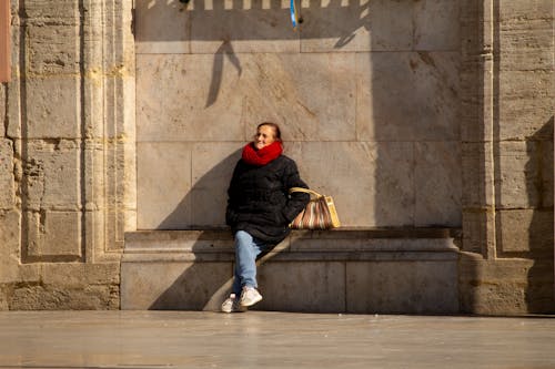 Woman Sititng by Sunlit Wall