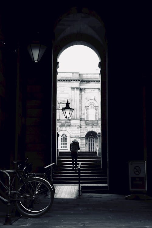 Фотография человека, идущего по лестнице в оттенках серого