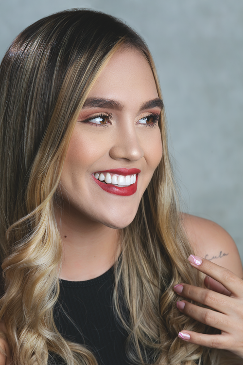 Free Studio portrait of a smiling young woman with red lipstick and long blonde wavy hair. Stock Photo