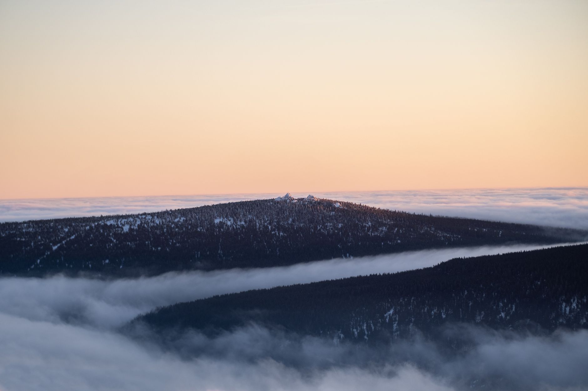 A serene winter landscape with snowcapped mountains surrounded by mist and soft sunrise colors.. pexels, serene, winter