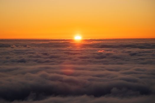 A breathtaking sunrise view over a blanket of clouds, captured from an aerial perspective.