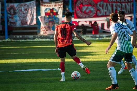 Dynamic soccer match with players in action at a stadium in Mendoza, Argentina.