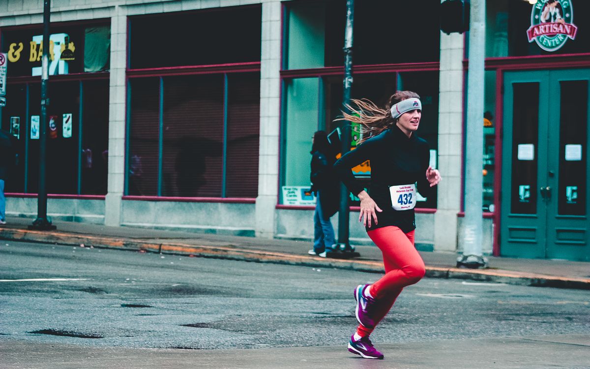 A runner sprinting past a storefront