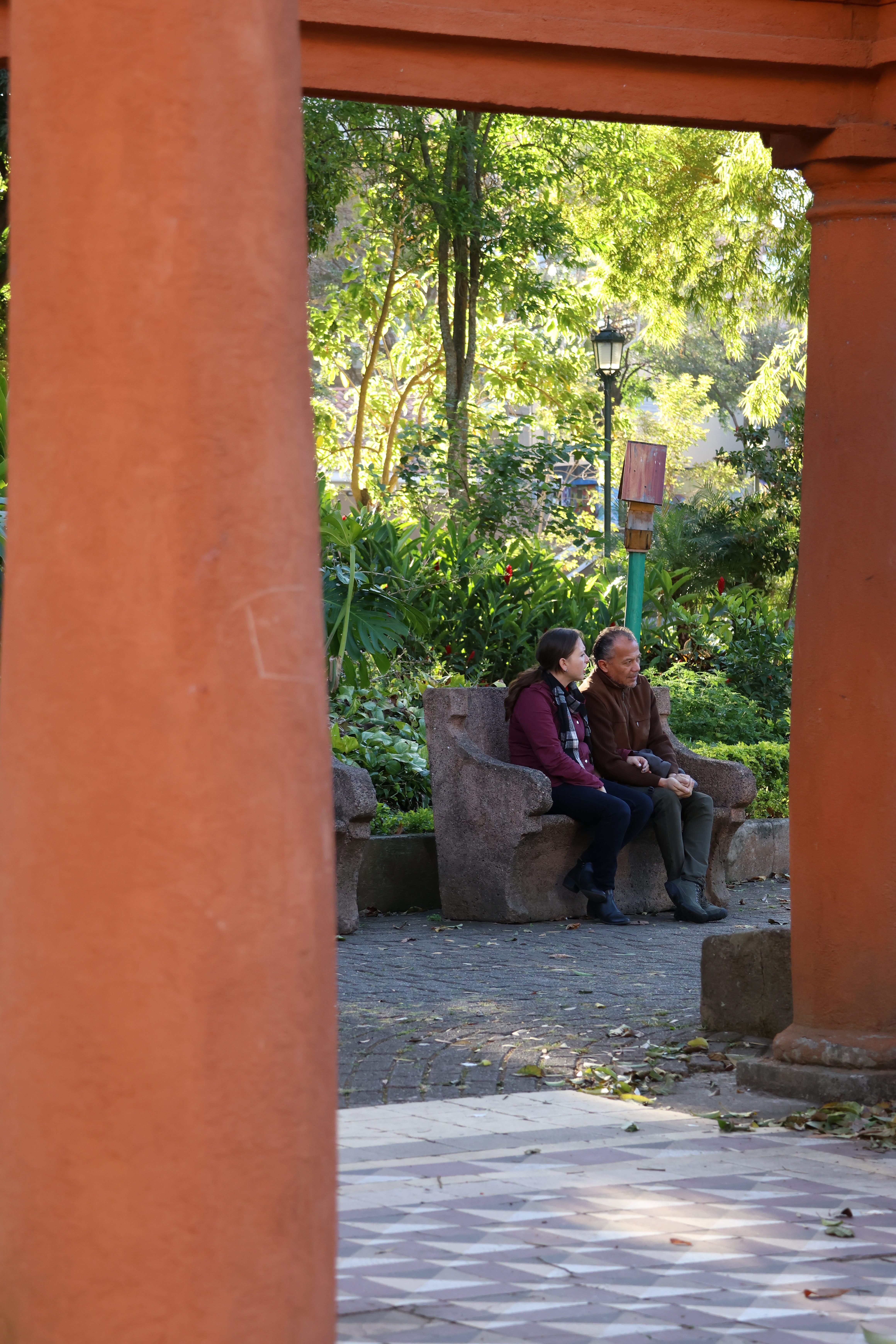 People Sitting on a Bench in front of a Gate · Free Stock Photo