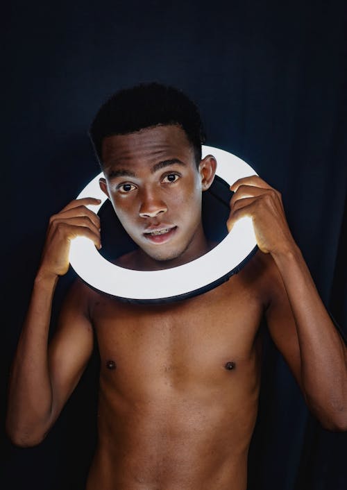 Young Man Holding a Ring Light around His Neck
