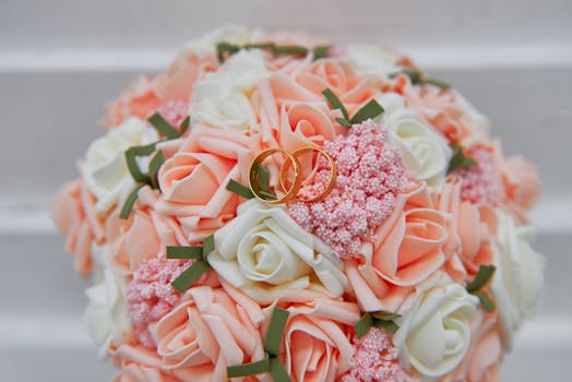 婚礼花束充满活力，以桃子玫瑰和金戒指装饰，象征着浪漫与庆祝