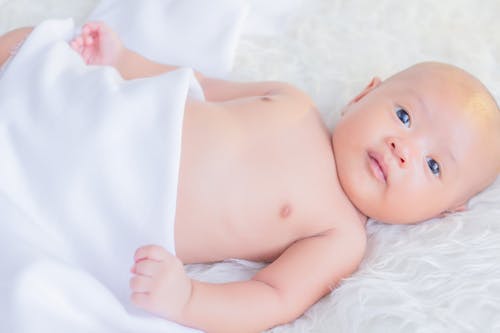 A Newborn Baby Lying on a Soft Blanket 