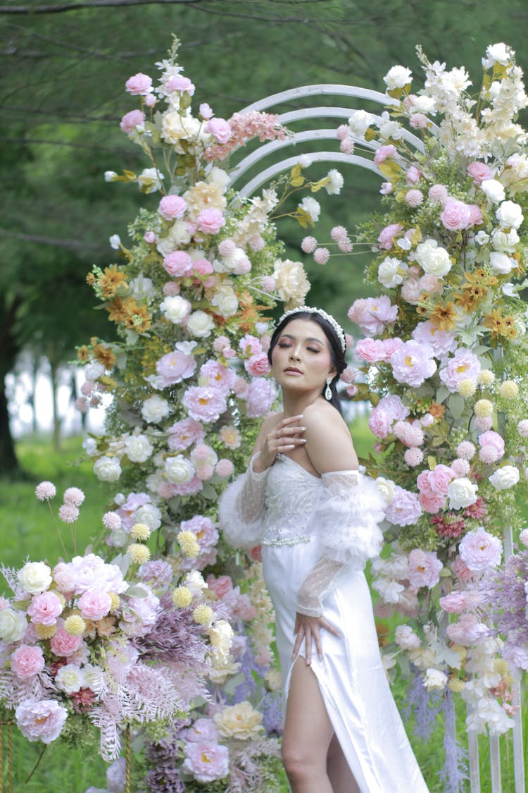 Bride In Wedding Dress Posing Near Floral Arch