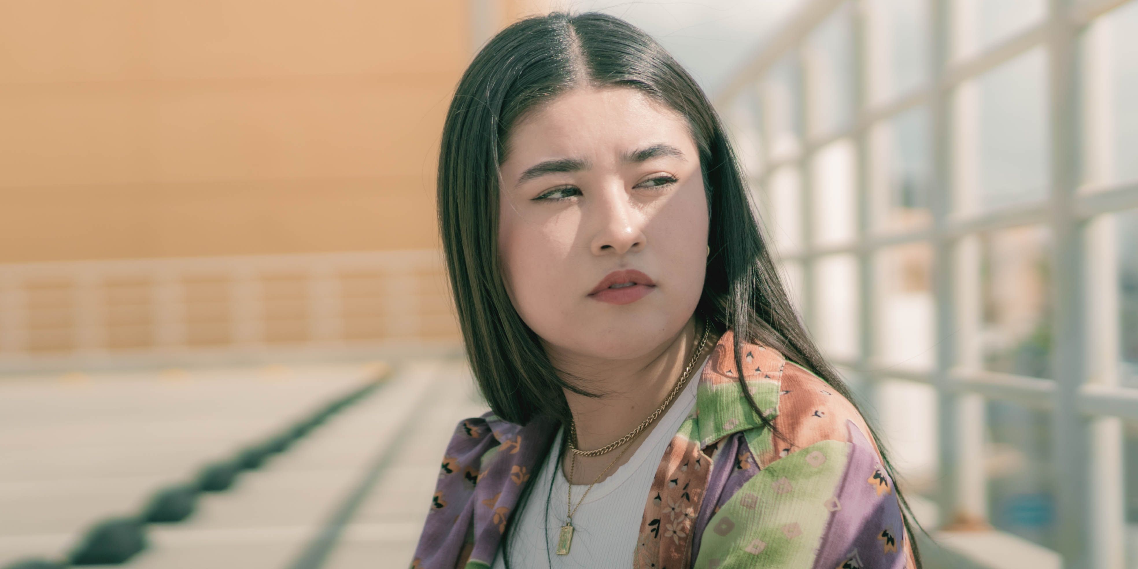 A young woman enjoying a sunny day outdoors, captured in a casual portrait.