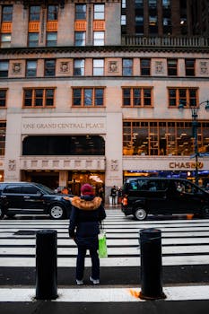 Back view of a pedestrian crossing a street at One Grand Central Place in New York City.