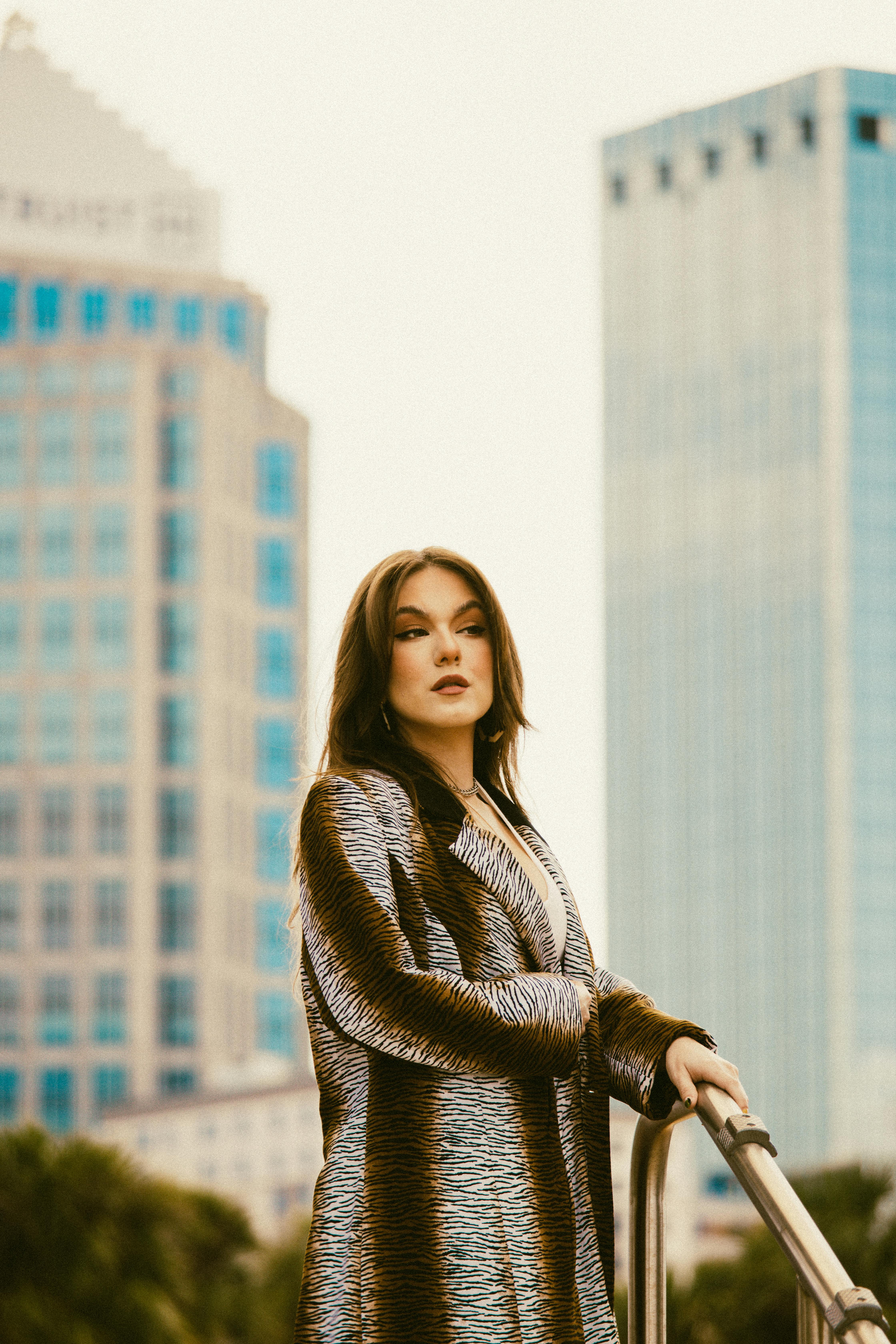 a woman in a fur coat standing on a railing