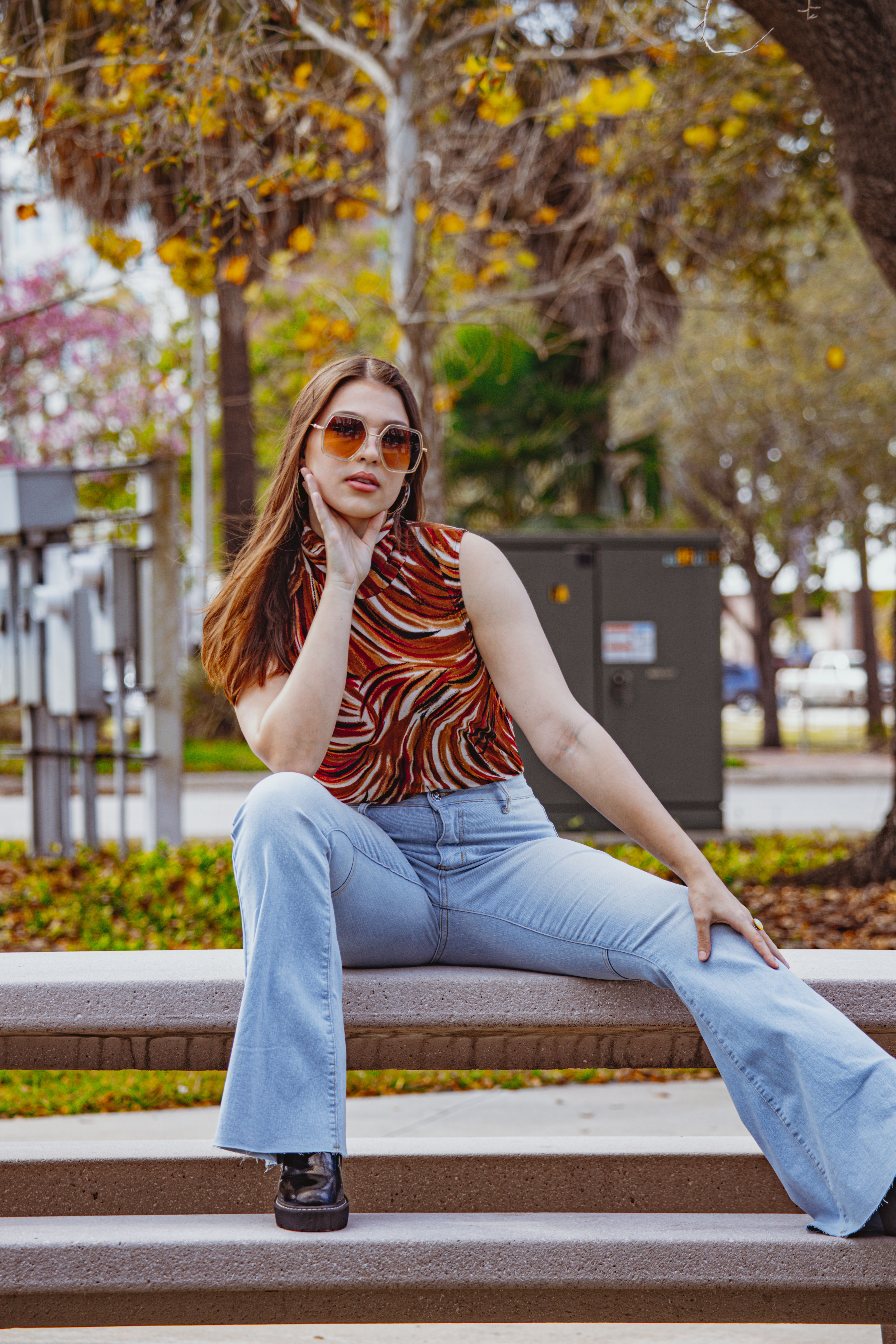 A woman in jeans and a top sitting on a bench · Free Stock Photo
